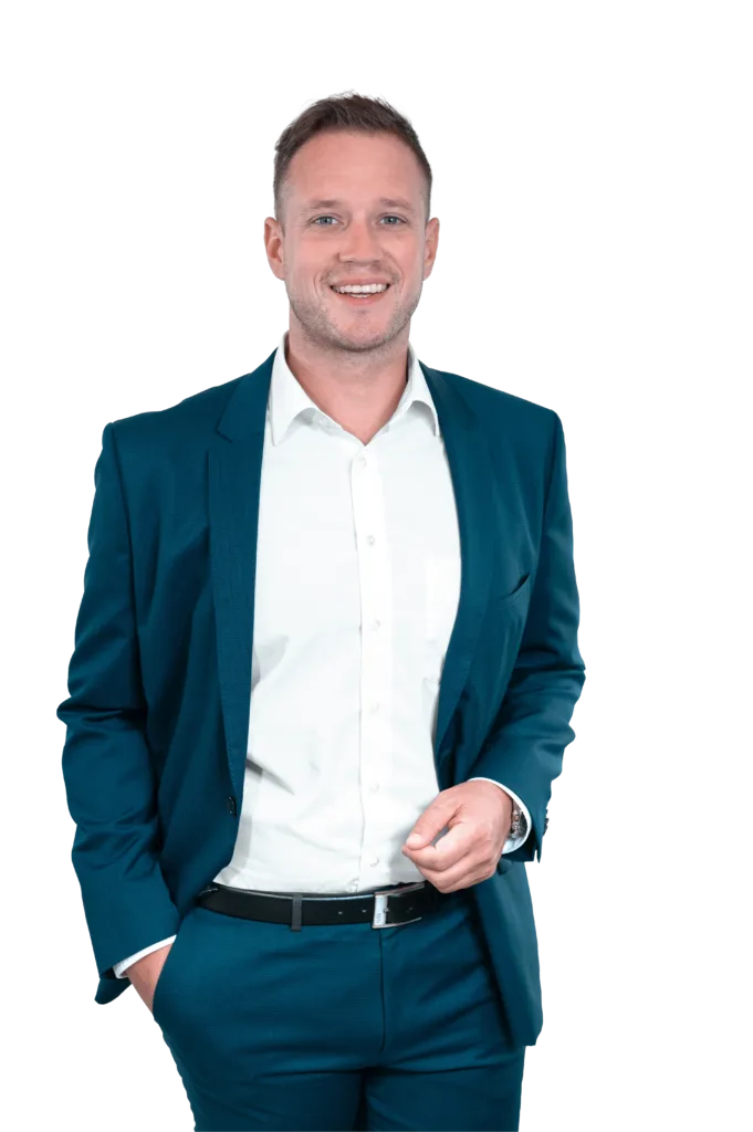 Matthias trägt einen blauen Anzug und schaut in die Kamera.