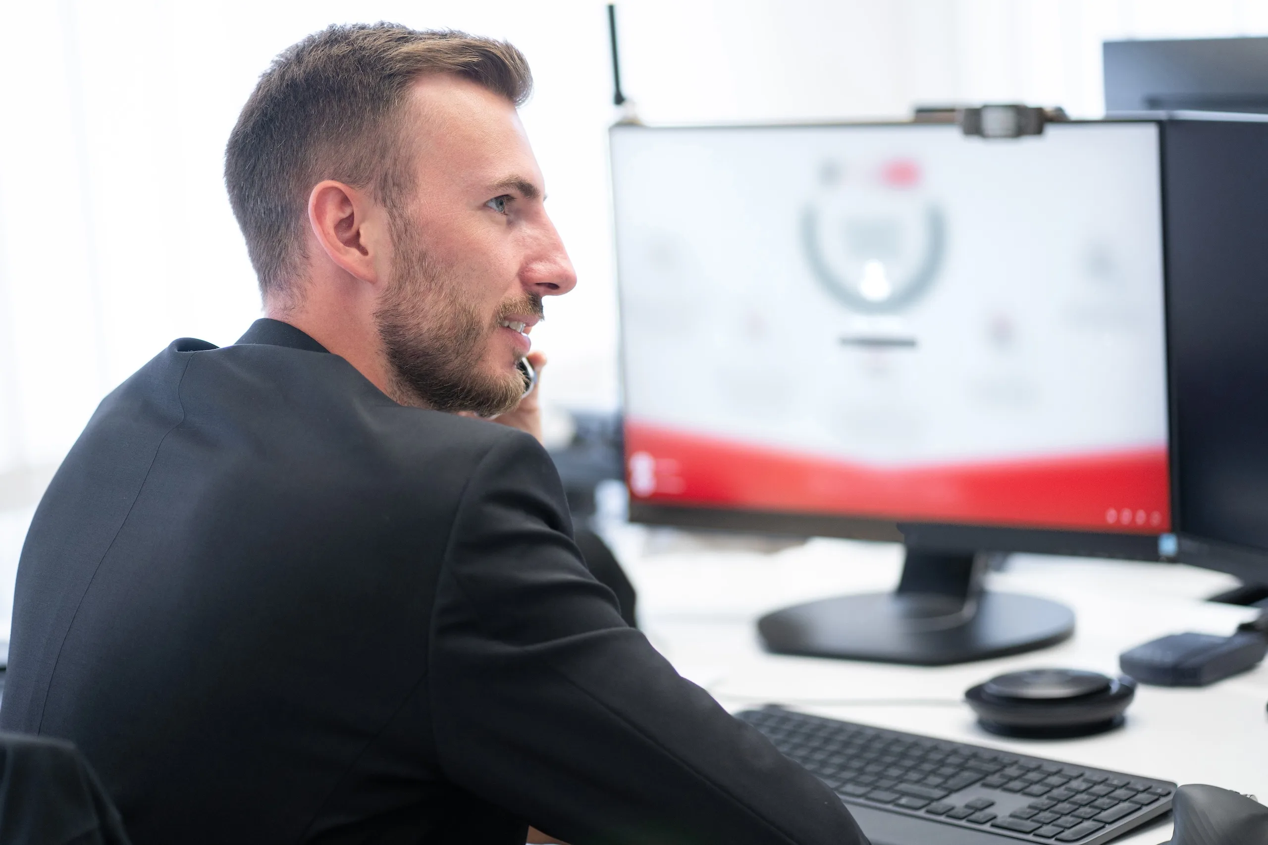 Geschäftsmann sitzt am Schreibtisch und telefoniert.