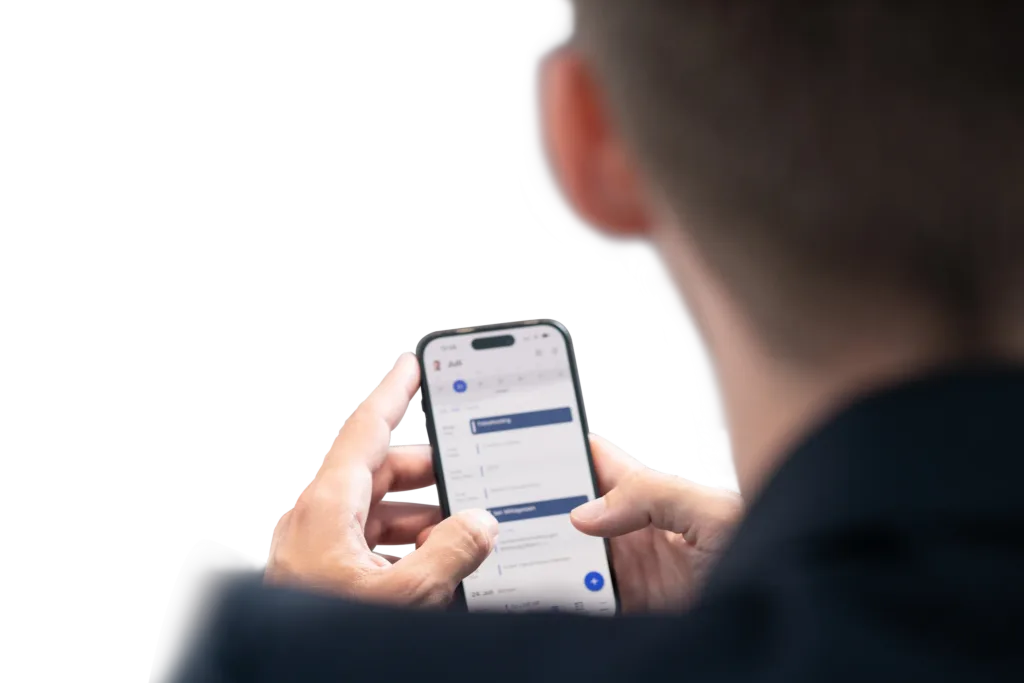 Eine Person überprüft ihren Kalender und plant Termine auf einem Smartphone.