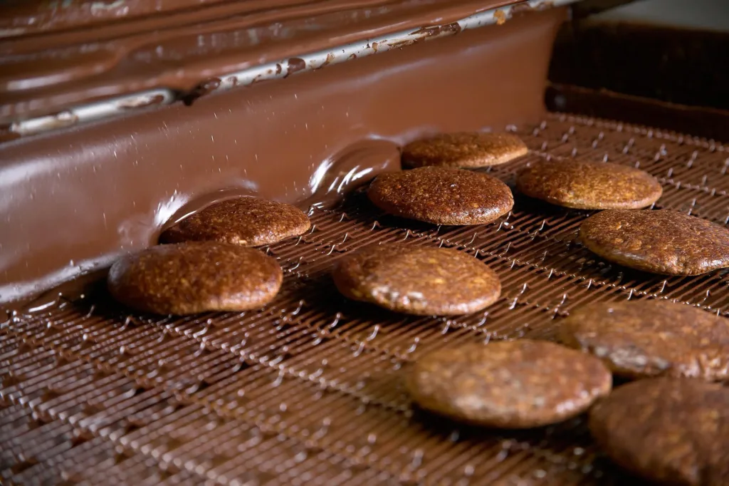 Lebkuchen werden in der Herstellung am Fließband glasiert.