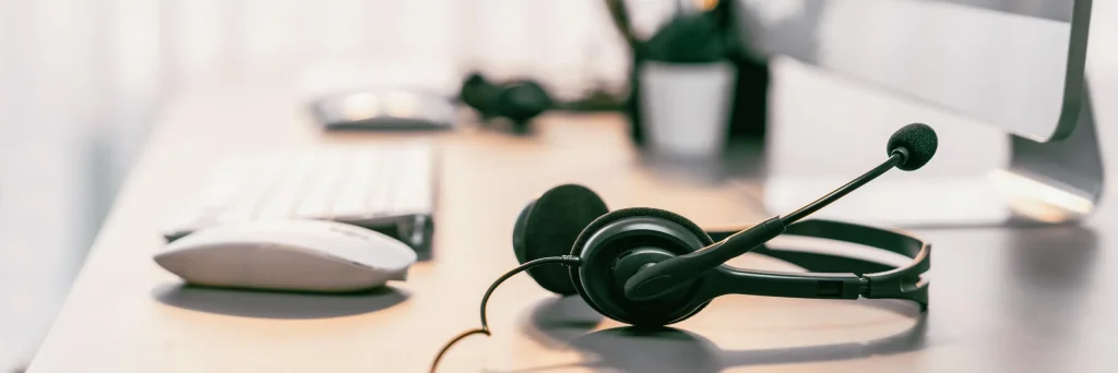 Ein leerer Arbeitsplatz auf welchem ein Headset liegt.